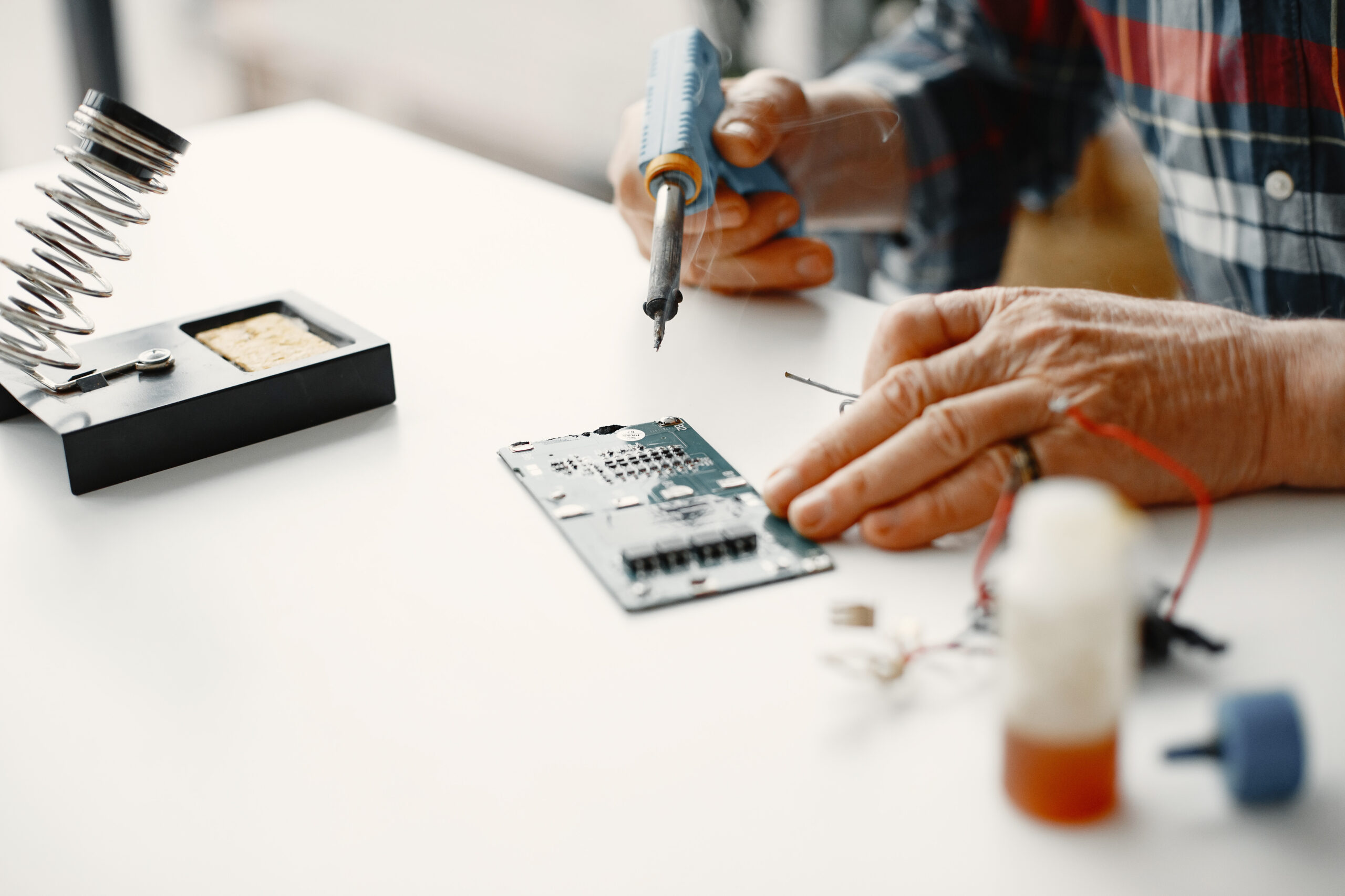 Male tech repairs electronic equipment at home
